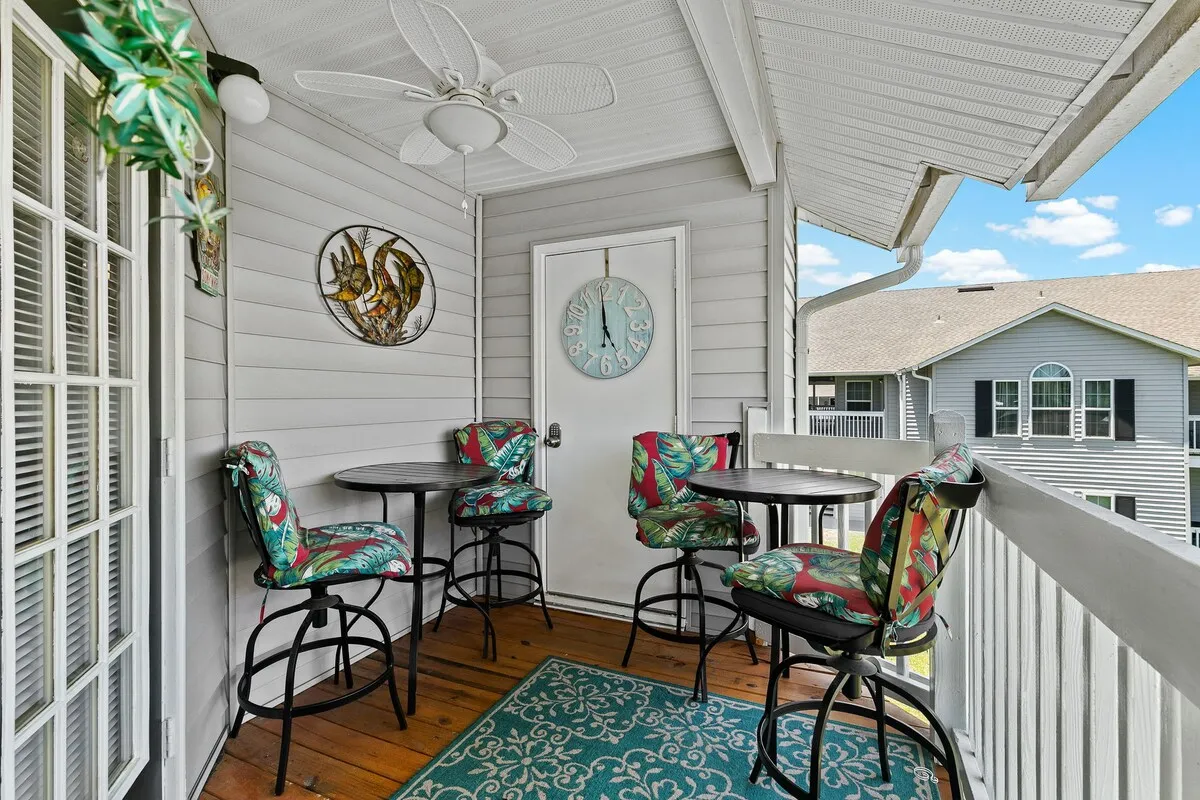 Covered balcony with outdoor tables and seating.